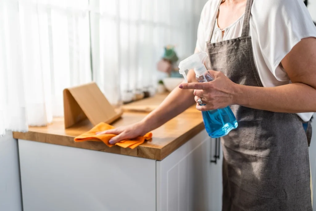 Close up of woman wiping down kitchen benches
